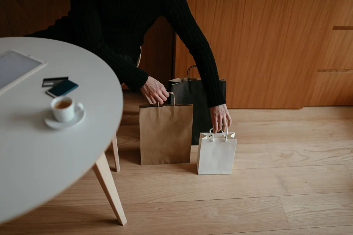 Bolsas de compras junto a una taza de café y una tablet