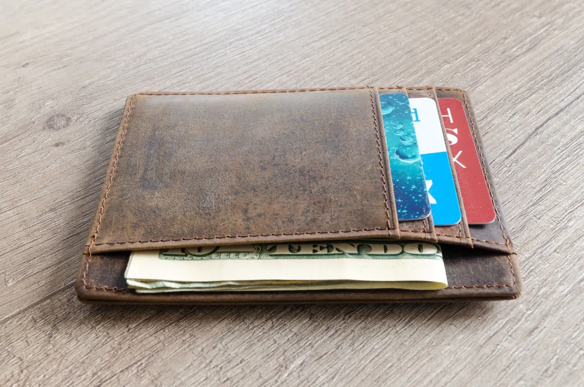Billetera con tarjetas y billetes de dólar